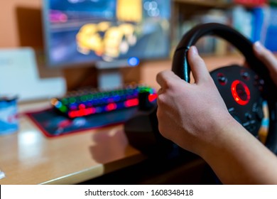 Teenage Boy Playing On Truck Driving Simulator  In Front Of A Computer With Glowing Keyboard, Focus On The Boys Hand, Shallow Depth Of Field, Copy Space.