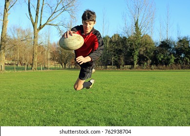 Teenage Boy Playing Rugby On A Sports Field, Scoring A Try.  - Powered by Shutterstock