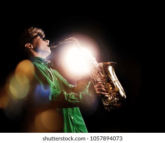 Teenage Boy Playing Sax On A Dark Stage