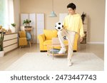 Teenage boy playing with soccer ball at home