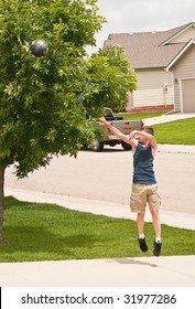 Teenage Boy Shooting A Basketball At His Home Practice Hoop