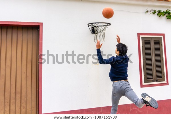 Teenage Boy Shoots Basketball Towards Hoop Stock Photo Edit Now