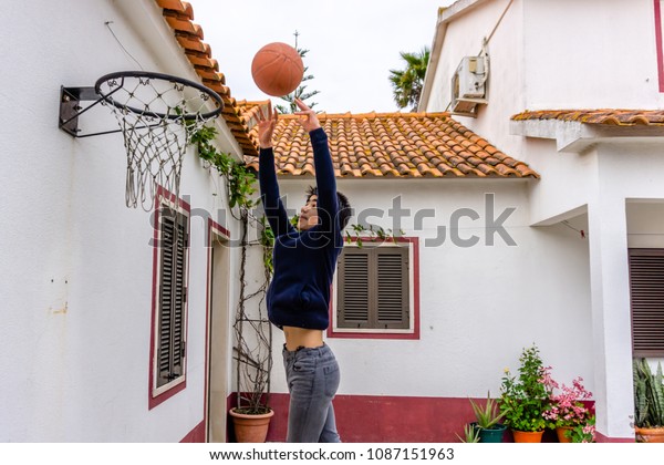 Teenage Boy Shoots Basketball Towards Hoop Stock Photo Edit Now