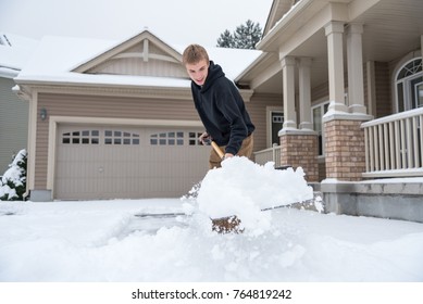 Teenage Boy Shoveling Driveway