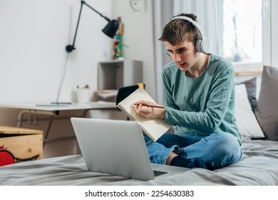 Teenage boy shows his homework in the online class - Shutterstock ID 2254630383