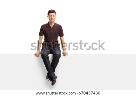 Teenage boy sitting on a panel isolated on white background