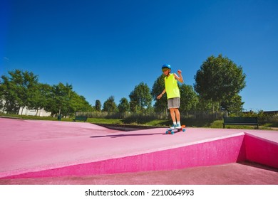 Teenage Boy Skate Stand A Skateboard At Skatepark Going Down The Ramp With Color Pink Surface Wearing Helmet