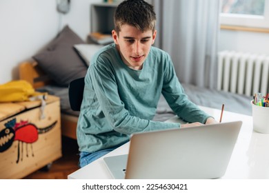 Teenage boy studies at home - Shutterstock ID 2254630421
