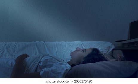 Teenage Boy Suffering From Insomnia Lying In Bed At Night.