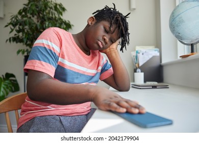 Teenage Boy Taking A Break From Social Media After Abuse And Bullying Laying Mobile Phone Down On Table - Powered by Shutterstock