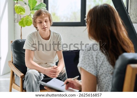 Teenage boy talking to female professional psychologist counselor therapist
