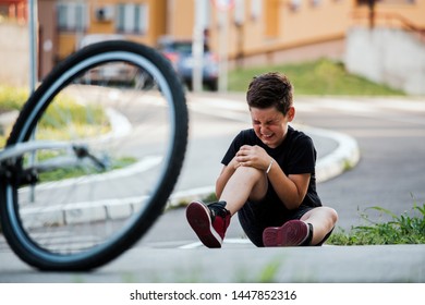 Teenage Boy There Is A Knee Injury, As The Bike Falls While Riding. Kid Hurt His Leg After Falling Off His Bicycle