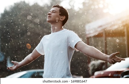 Teenage Boy Under Rain In The City