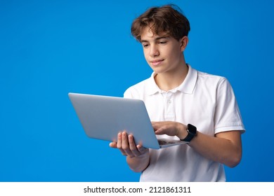 Teenage boy using laptop against blue background - Powered by Shutterstock