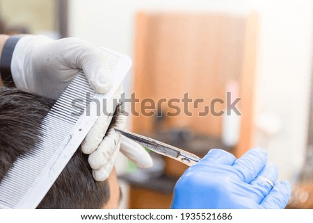 Similar – Beautiful boy getting a haircut with scissors