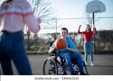 Teenage Boy In Wheelchair Playing Basketball With Friends - Powered by Shutterstock