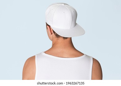 Teenage boy in white snapback cap and tank top street fashion shoot rear view