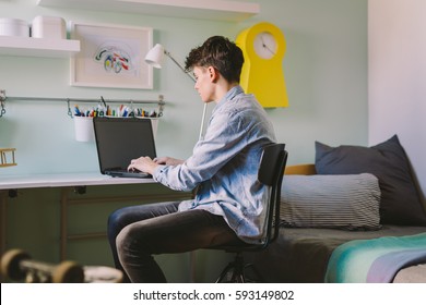 Teenage Boy Working On Laptop  In His Room