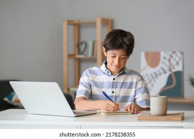 Teenage boy writing in notebook at home - Powered by Shutterstock