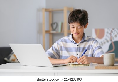 Teenage Boy Writing In Notebook At Home