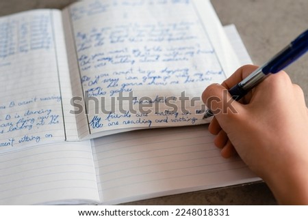 Teenage boy writing with pen in notebook. Kid doing school homework. Education, learning difficulties, bad handwritting concept