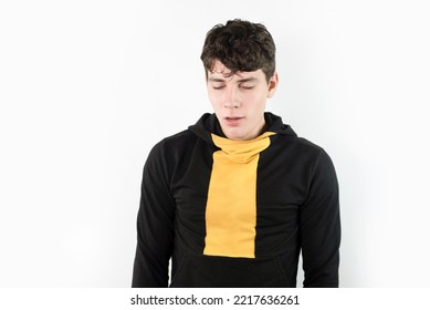 A Teenage Boy Yawns, He Is Tired After Active Study And Sports. Tired Sleepy Teenager Yawns On A White Background, Copy Space