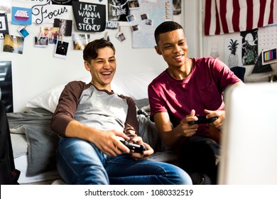 Teenage Boys Hanging Out In A Bedroom Playing Video Games Together