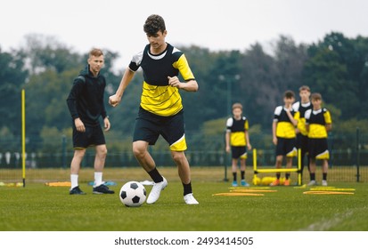 Teenage Boys Training Sports . Soccer Summer Camp for Young Boys. Happy Football Players on Practice Session. Youth Team Kicking Balls on Turf Pitch. Soccer Training Trail With Equipment - Powered by Shutterstock