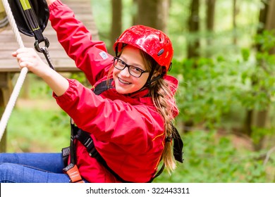 Teenage Child Enjoying Climbing On A High Rope Course 