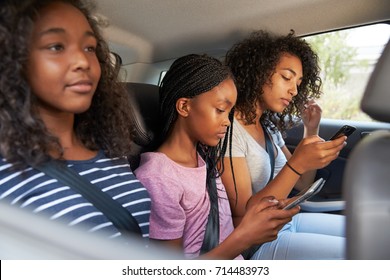 Teenage Children Using Digital Devices On Family Road Trip - Powered by Shutterstock