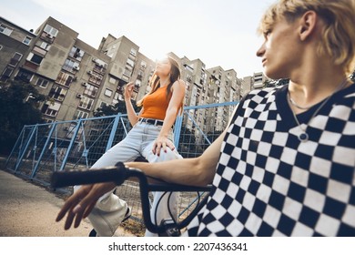 Teenage couple hanging out outside in urban exterior. - Shutterstock ID 2207436341