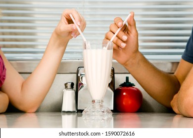 Teenage couple sharing a milkshake - Powered by Shutterstock