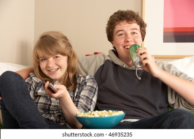 Teenage Couple Sitting On Sofa Watching TV