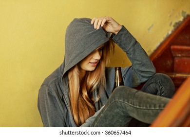 Teenage Depressed Woman Sitting On The Staircase And Drinking A Beer