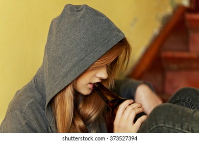 Teenage Depressed Woman Sitting On The Staircase And Drinking A Beer