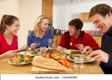 Teenage Family Eating Lunch Together In Kitchen