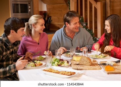 Teenage Family Enjoying Meal In Alpine Chalet Together