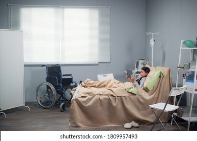 Teenage Female Patient Relaxing In Hospital Bed With Digital Tablet.