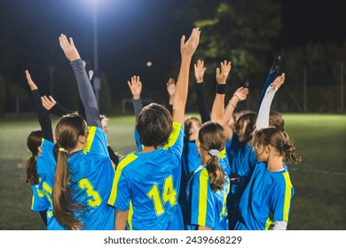 teenage footbal player girls heating up before match and holding hands in the air, team sport concept. High quality photo - Powered by Shutterstock