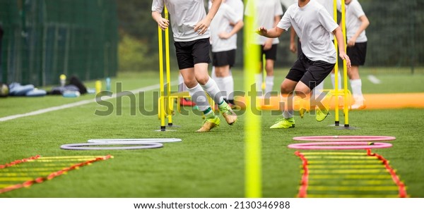 Teenage Football\
Players Running in Two Rows on Training Camp. Young Boys Running\
Slalom Track Between Training Poles and Jumping Over Ladders.\
Soccer Training\
Equipment