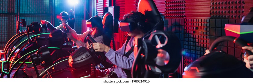 teenage friends in vr headsets gaming on car racing simulators, banner
