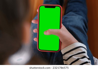 Teenage girl of 12 years with backpack holds a mobile phone green screen, chromakey. Advertising. Children's app, education, learning a foreign language. School Child showing smartphone greenscreen. - Powered by Shutterstock