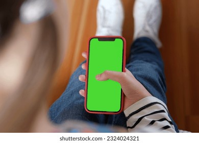 Teenage girl of 12 years with backpack holds a mobile phone green screen, chromakey. Advertising. Children's app, education, learning a foreign language. School Child showing smartphone greenscreen. - Powered by Shutterstock