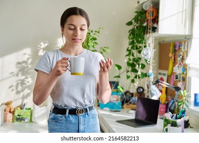 Teenage Girl 14, 15 Years Old Holding Mug, Standing At Home