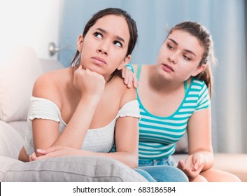 Teenage Girl Asking For Forgiveness From Her Offended Female Friend Sitting Sofa