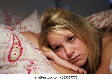 Teenage Girl Awake In Bed Suffering With Insomnia