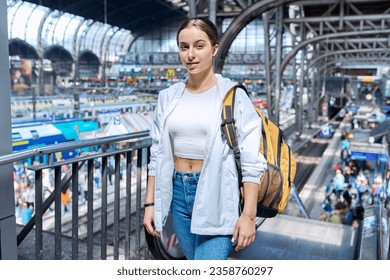 Teenage girl with backpack looking at camera at railway station - Shutterstock ID 2358760297
