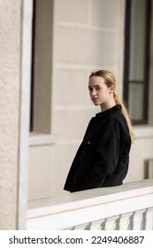 A teenage girl in black denim jacket turned over her shoulder