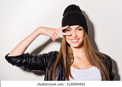 Teenage girl in black leather jacket and beanie hat posing a smiling - Powered by Shutterstock