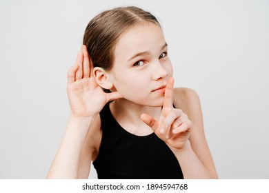 A Teenage Girl In A Black T-shirt Holds Her Hand By Her Ear And Listens. Secret Sales In Stores Only For A Select Few. Shopping. School Secrets.